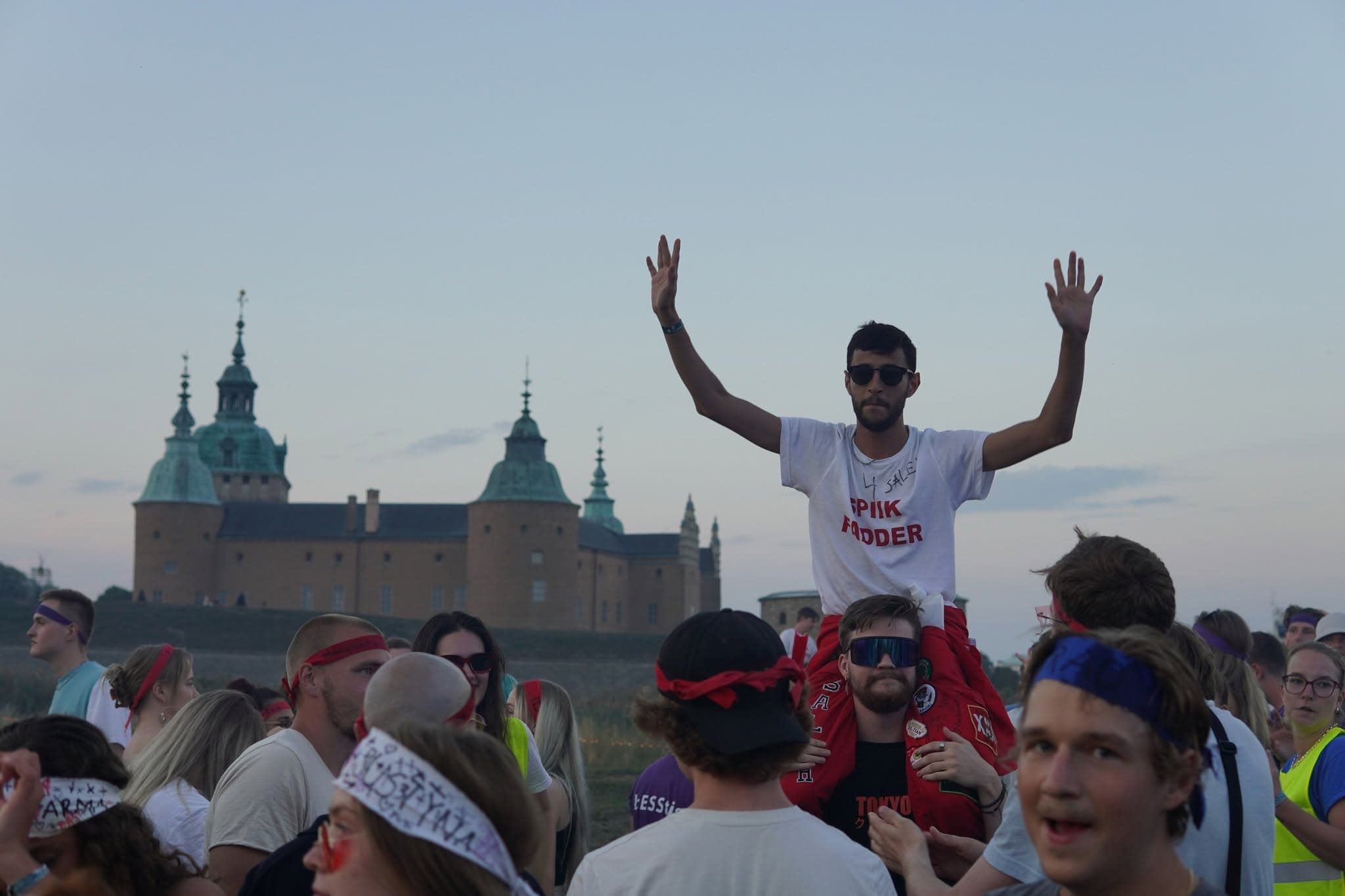 Bilden visar en överblicksbild på personer på nollningen  2024 med Kalmar slott  i bakgrunden